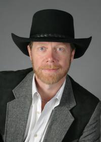 Guy Smith | Gun Facts | sitting in yoke jacket and hat