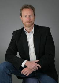 Guy Smith | Gun Facts | seated in black jacket